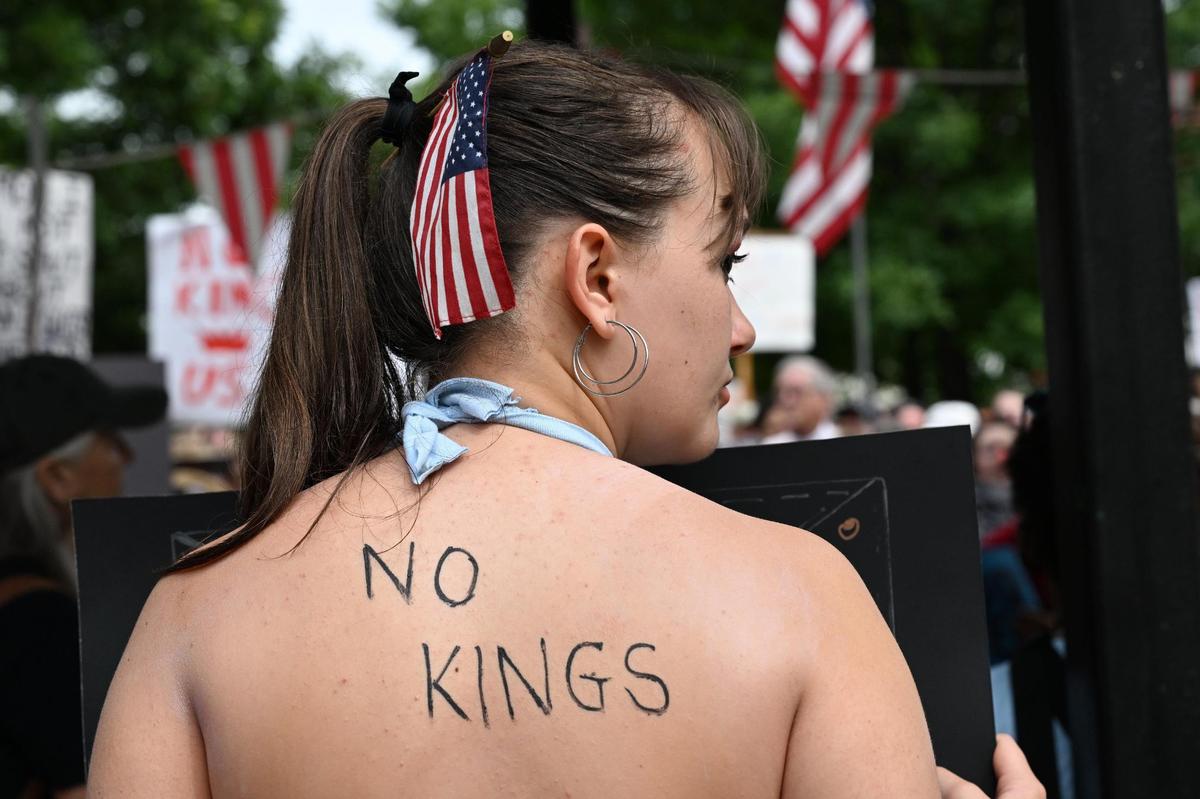 Cece O’Neill, 18, from Perry, Georgia, listens to speakers during a No Kings protest on Saturday, June 14, 2025, in downtown Macon, Georgia. Hundreds gathered in Macon on Saturday morning as one of many similar protests nationwide to criticize the policies of President Donald Trump ahead of a military parade held in Washington D.C. later today.