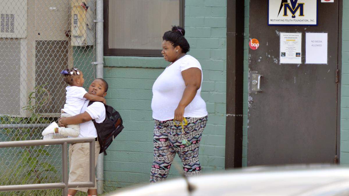 JASON VORHEES/THE TELEGRAPH Macon, GA, 08/12/2015: 
 Juquetta Milner walks out of the the Motivating Youth Foundation with her children Aviyon Farley, 7 and Jayla Brown, 2, Wednesday afternoon.