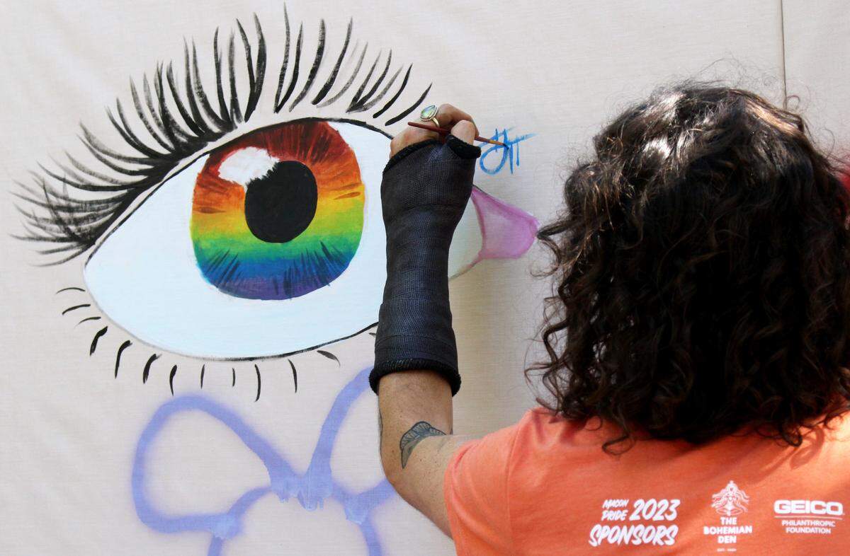 Josh Bilbrey, 28, signs his artwork on an open wall at Macon Pride’s Pride in the Park event Saturday, Sept. 30, 2023. The wall was open for participants of the event to paint.