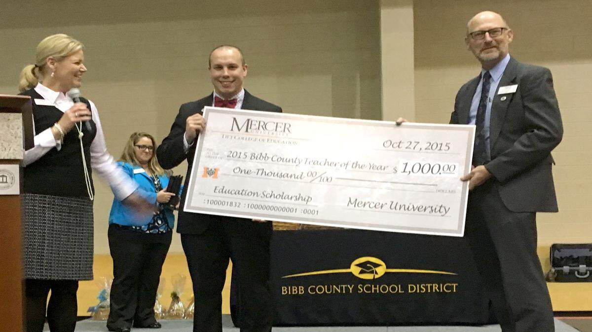 Morgan Jarvis, center, Bibb County's 2016 Teacher of the Year, receives a $1,000 Mercer University scholarship from James Barda, dean of Mercer's Tift College of Education, right. The money will go toward earning a graduate-level degree. Penny Elkins, Mercer's senior vice president for enrollment management, is on the left.