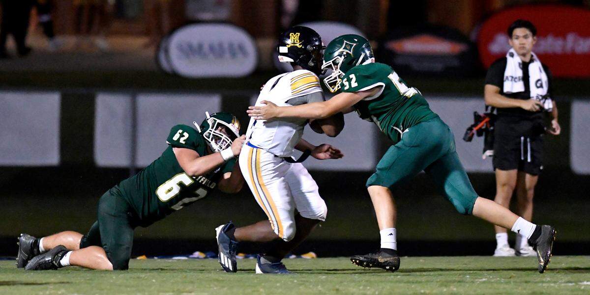 Mount de Sales quarterback Zavion DeShazier (3) is sacked by Westfield’s Sammy Mcgehee (52) and Rigdon McCall (62) during their game Friday night.