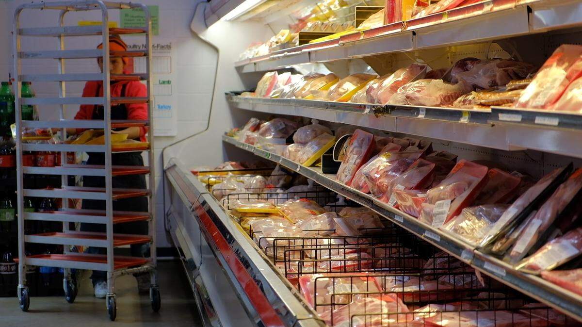 An employee at My Store on Pio Nono Avenue restocks the meat and poultry section. No other stores sell fresh meat within a two-mile radius of the Kroger that closed in April.