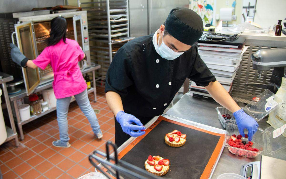 Tai Nguyen, owner of Sweet of Life in Bonaire places a raspberry on a fruit tart.