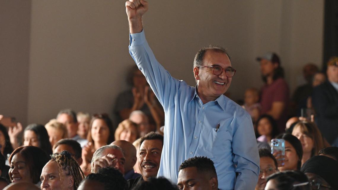 Henry Tovar, originally from Colombia, stands and pumps his fist during a country roll call during the naturalization ceremony on Tuesday, Oct. 1, 2024, at the Jimmy Carter National Historical Park in Plains, Georgia. Tovar from Newton, Georgia was one of 100 new United States citizens naturalized at the old Plains High School to celebrate former president Jimmy Carter’s 100th birthday in his hometown of Plains.