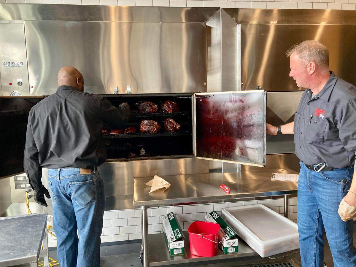 Pit master Robert Jones, left, checks the meats slow-smoked on site at the new Sonny’s BBQ at 5811 Zebulon Road in Macon.