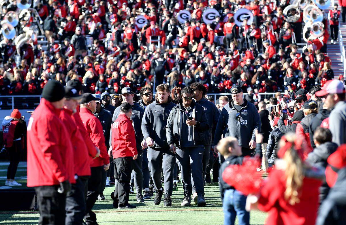 Georgia players walk into Sanford Stadium quarterback Saturday during the Bulldogs’ National Championship celebration.