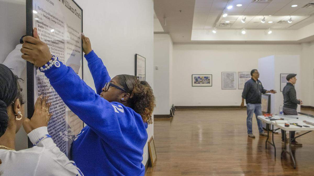 Mercer University sophomore Taylor Boyd mounts a piece of the Freedom Seekers exhibit at the Tubman African American Museum in Macon in 2025. The exhibit features so-called “runaway slave ads” researched by students like Boyd. “They had everyday problems just like us,” Boyd said. “Reading their stories and reading that they were running away to families or they had lovers — that really just exemplified the importance of why we need to showcase this.”