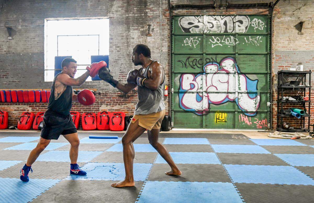 Bubby Mitchell, left, owner of Rush Mixed Martial Arts & Fitness spars with Quinten Culpepper Thursday night at the gym.