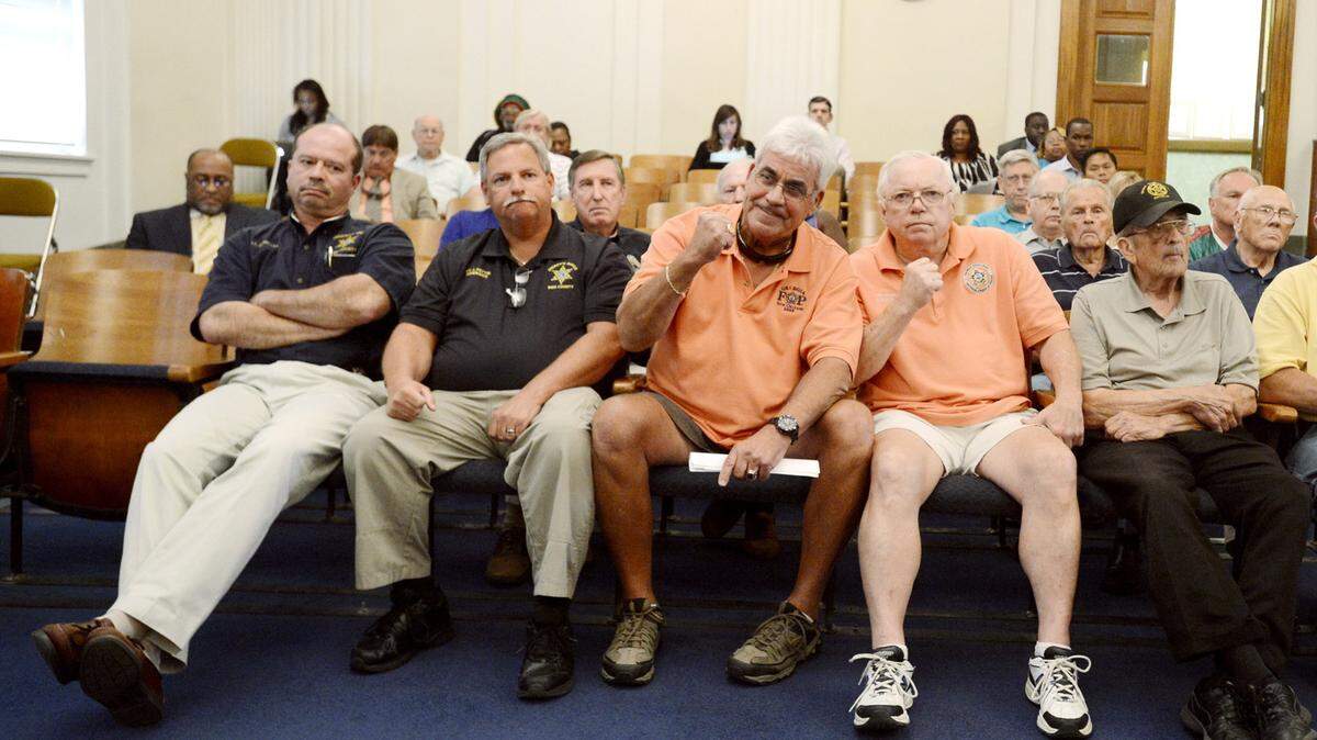Fraternal Order of Police Lodge No. 3 President Danny Thigpin, center, and Vice President Richard Kory give a fist pump after Macon-Bibb commissioners voted to increase the monthly pension amount for those in the fire and police pension fund.