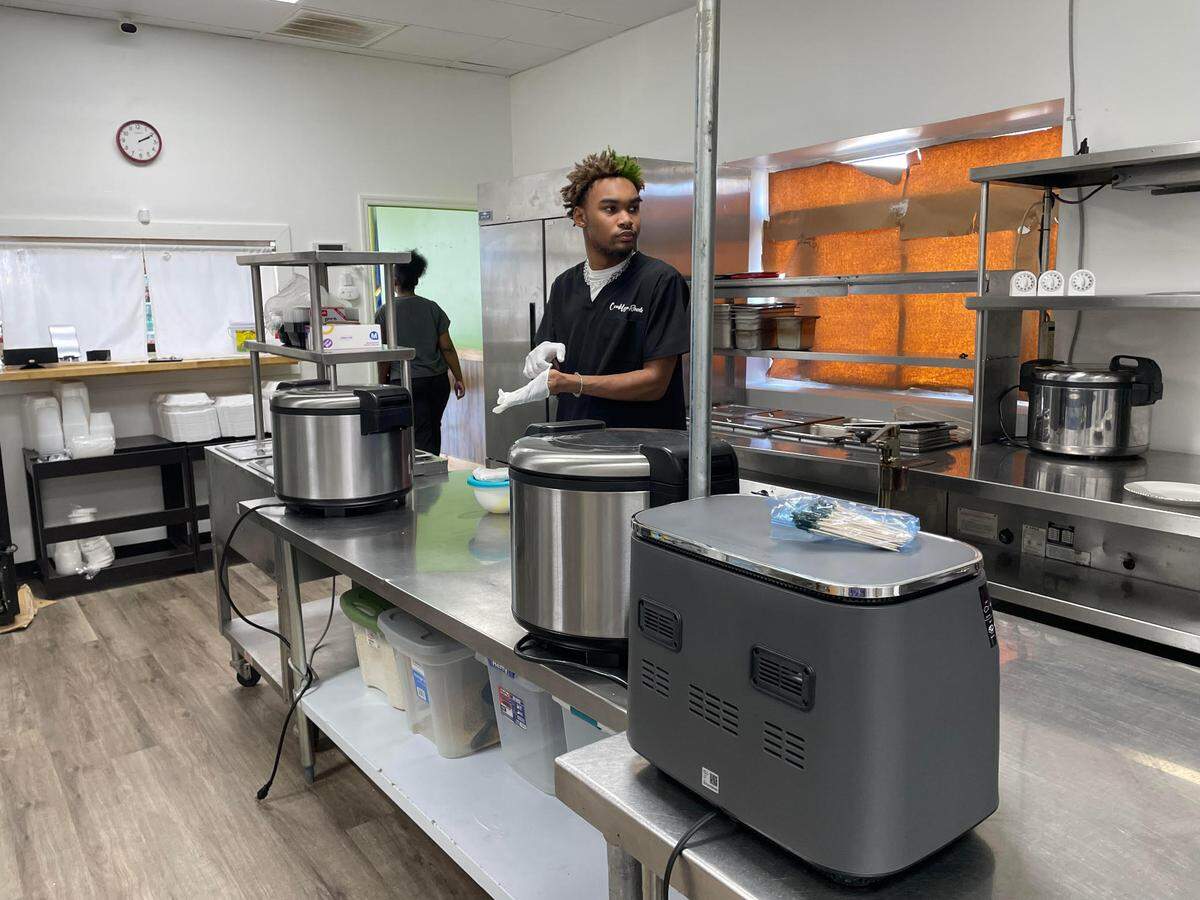 Tyler Cunningham gets ready to plate some dishes at Crooklyn Roots, a new geared-for-take-out restaurant that offers authentic Jamaican cuisine and vegan dishes in Byron.