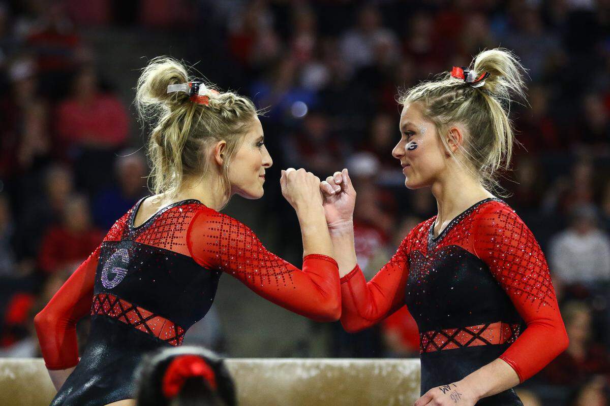 Georgia’s Sydney Snead wishes Georgia’s Rachel Dickson good luck before her beam routine during a Gym Dogs meet in Stegeman Coliseum in Athens, Ga., on Friday, Jan. 18, 2019. (Photo by Kristin M. Bradshaw)