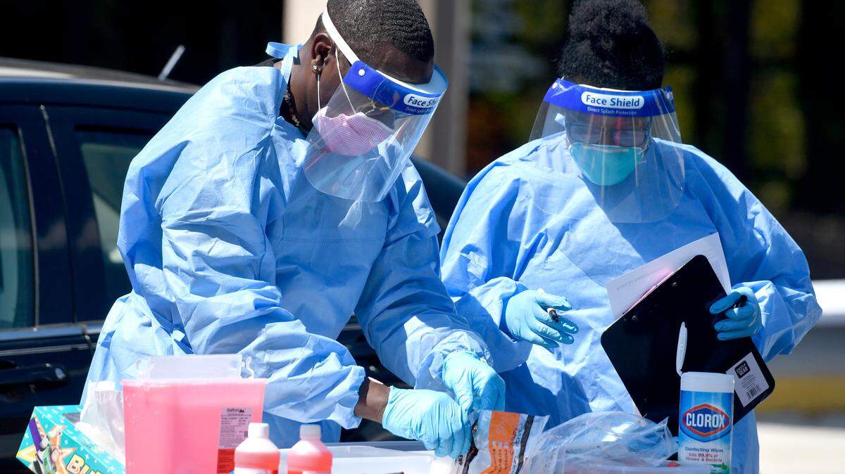 Community Empowerment Center health team medical volunteers with from Atlanta gather COVID-19 testing samples recently at the Community Church of God in Macon.