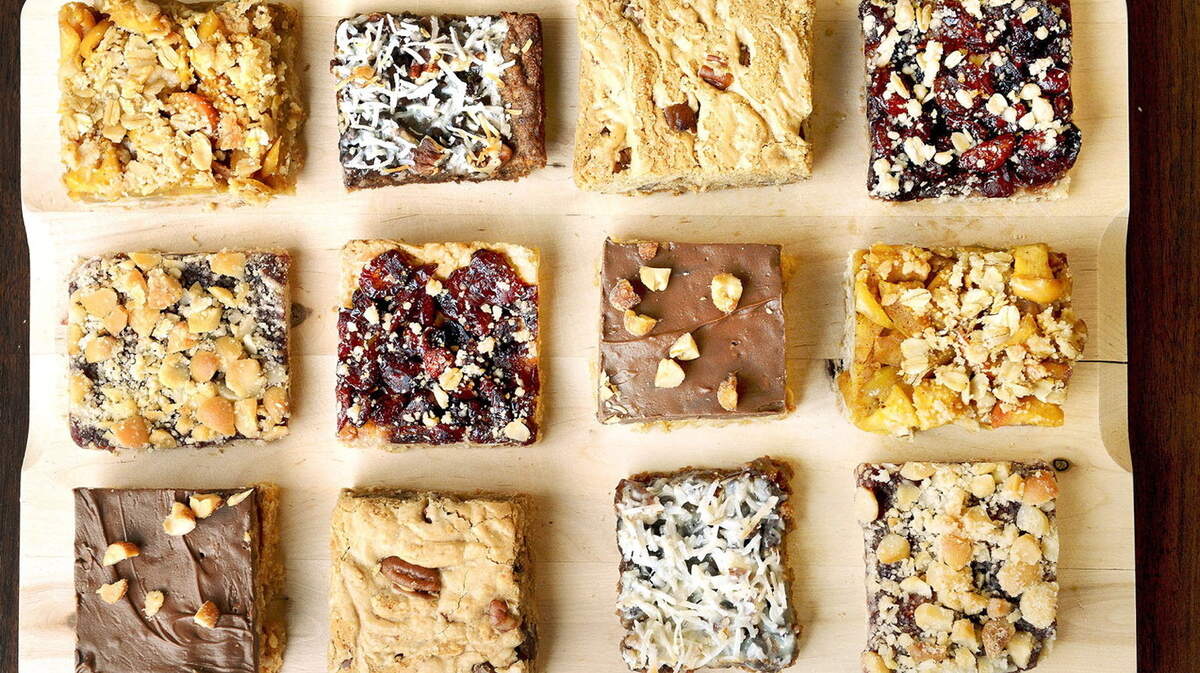 A tray of dessert bars featuring Cranberry Pear Bars, Apple Crumb Bars, Hazelnut Jam Bars, Chocolate-Coconut Bar, Chocolate-Butterscotch Crispy Bars and Jack's Favorite Blondies.