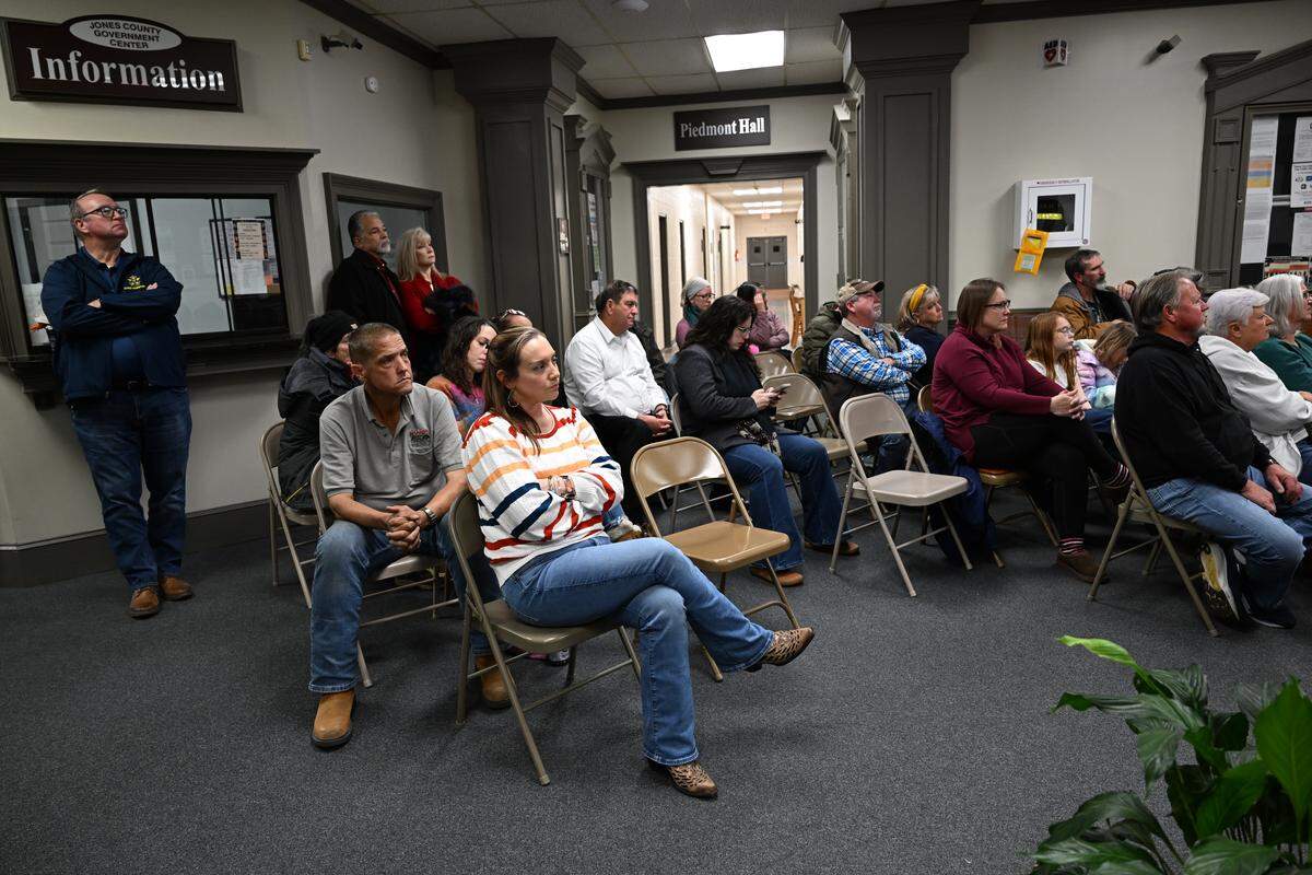 Attendees sit in overflow lobby seating and watch a livestream of a called meeting by the Jones County Board of Commissioners on a text amendment to allow for data centers on Friday, Jan. 16, 2026, at the Jones County Government Center in Gray, Ga. The board of commissioners unanimously passed the text amendment that would allow data centers with conditional use in the Griswoldville Industrial Park.