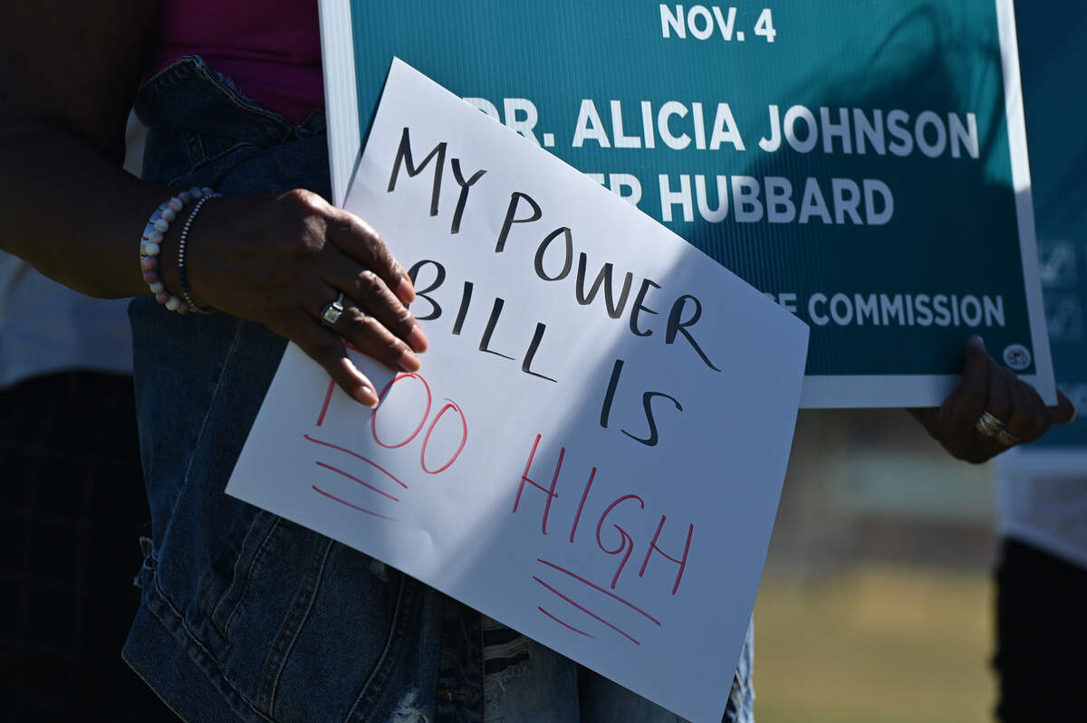 An attendee holds a “My Power Bill is Too High” poster during a campaign event for Public Service Commission democratic candidate Peter Hubbard on Tuesday, Oct. 14, 2025, outside Carolyn Crayton Park in Macon, Georgia. Hubbard is running for one of two seats on the Georgia PSC that are on the ballot this November.