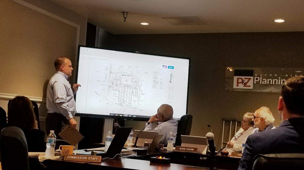 Brian Kay, left, a Marietta engineer representing the developer, goes over the site plan at the Aug. 13 zoning meeting for a proposed shopping center with a “high-end” grocery store on Thomaston Road at Tucker Road in west Bibb County.