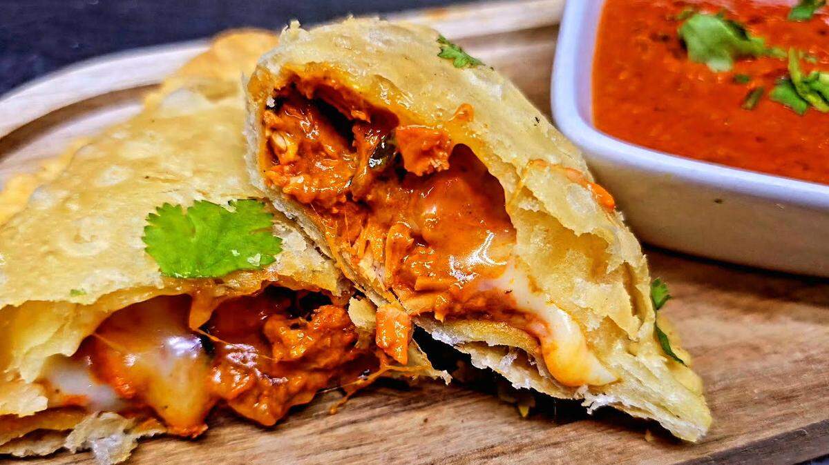 “Not Your Mother’s Samosa” from Slice & Spice in Warner Robins is filled with cheese and butter chicken, and served with makhani sauce.