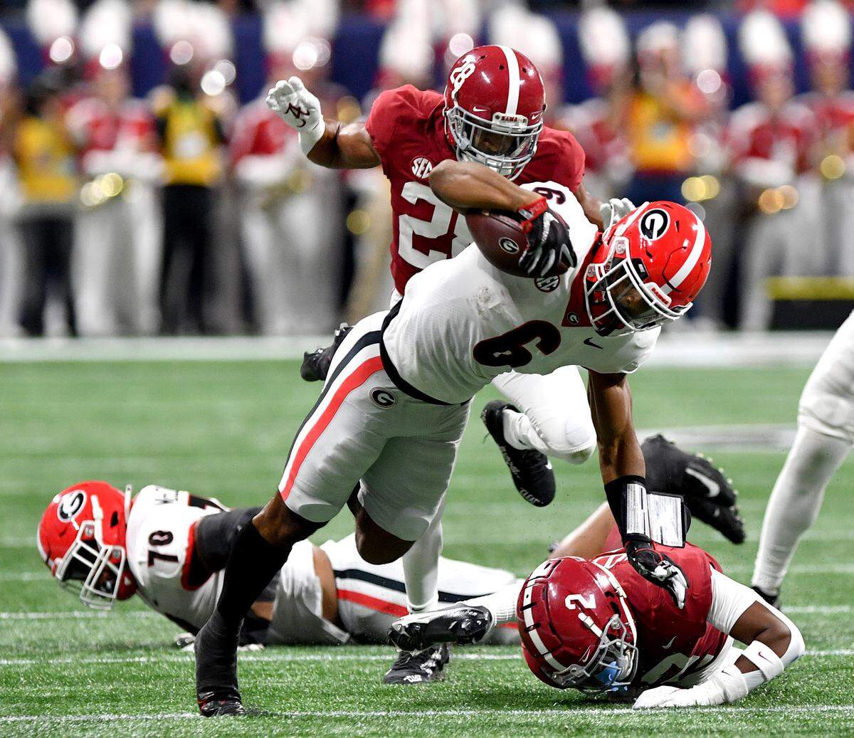 Georgia running back Kenny McIntosh (6) is tripped up Saturday during the Bulldogs’ SEC Championship game against Alabama.