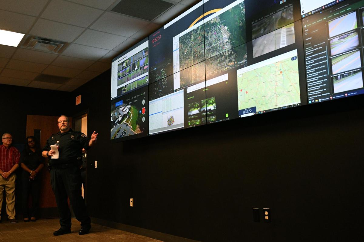 Warner Robins Police Department Captain Eric Gossman (left) points out the different live feeds during a tour of the new Real Time Crime Center on Tuesday, June 17, 2025, at the Law Enforcement Center in Warner Robins, Georgia. The Real Time Crime Center brings traffic cameras, license plate readers, public safety databases and social media monitoring information into one centralized hub for the WRPD to analyze as events occur.