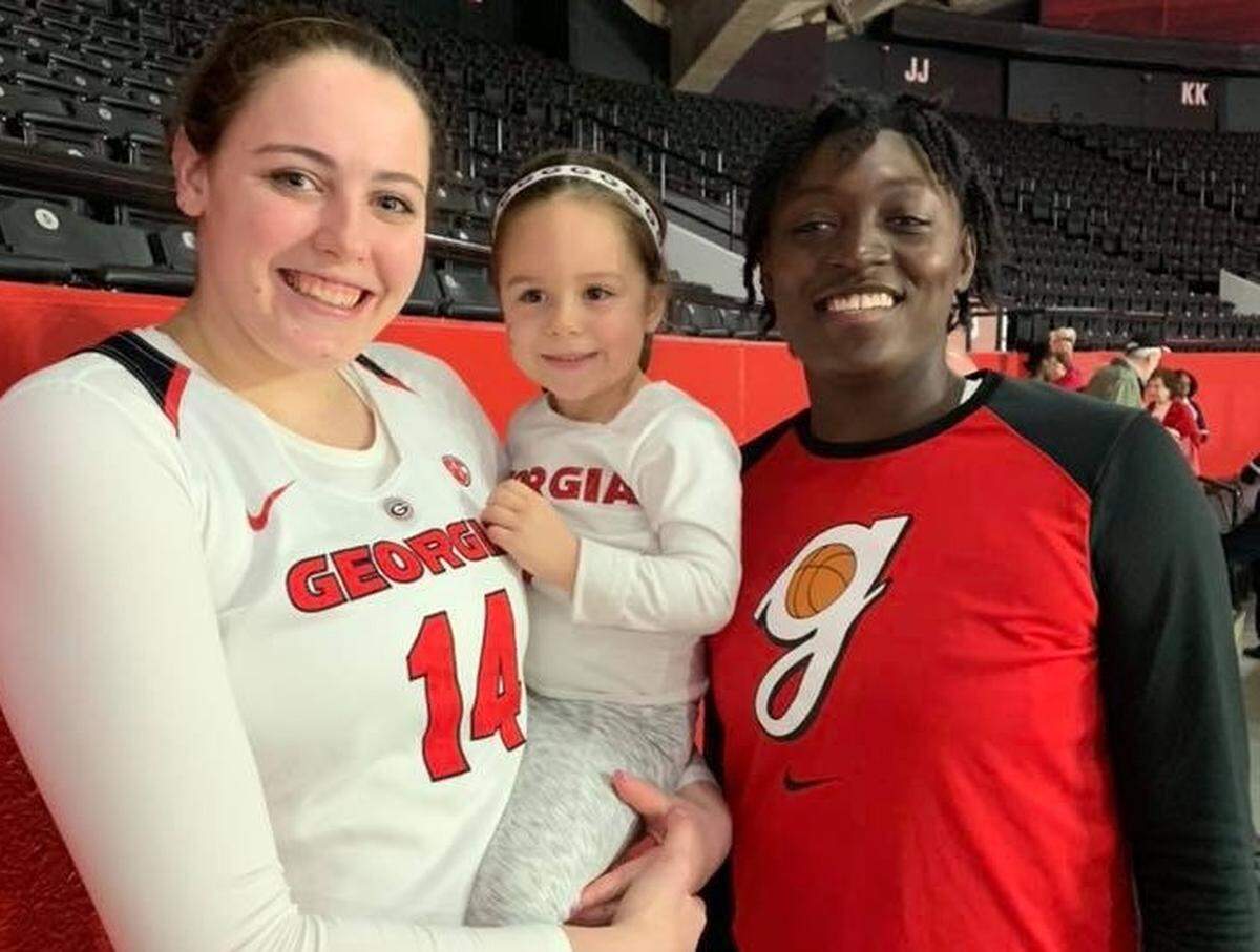 Aven Howell, center, poses for a photo with Lady Bulldogs Jenna Staiti and Caliya Robinson. Aven, a 4-year-old superfan, has developed a close relationship with Robinson.
