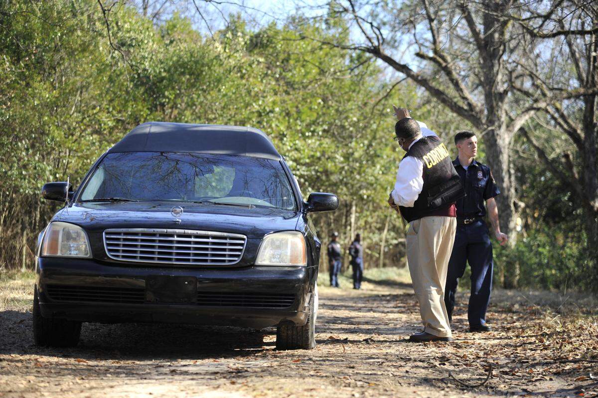 Bibb County Coroner Leon Jones in a vacant lot on Pinson Street in south Macon where the body of a 15-year-old boy was found in some bushes along a wooded path.