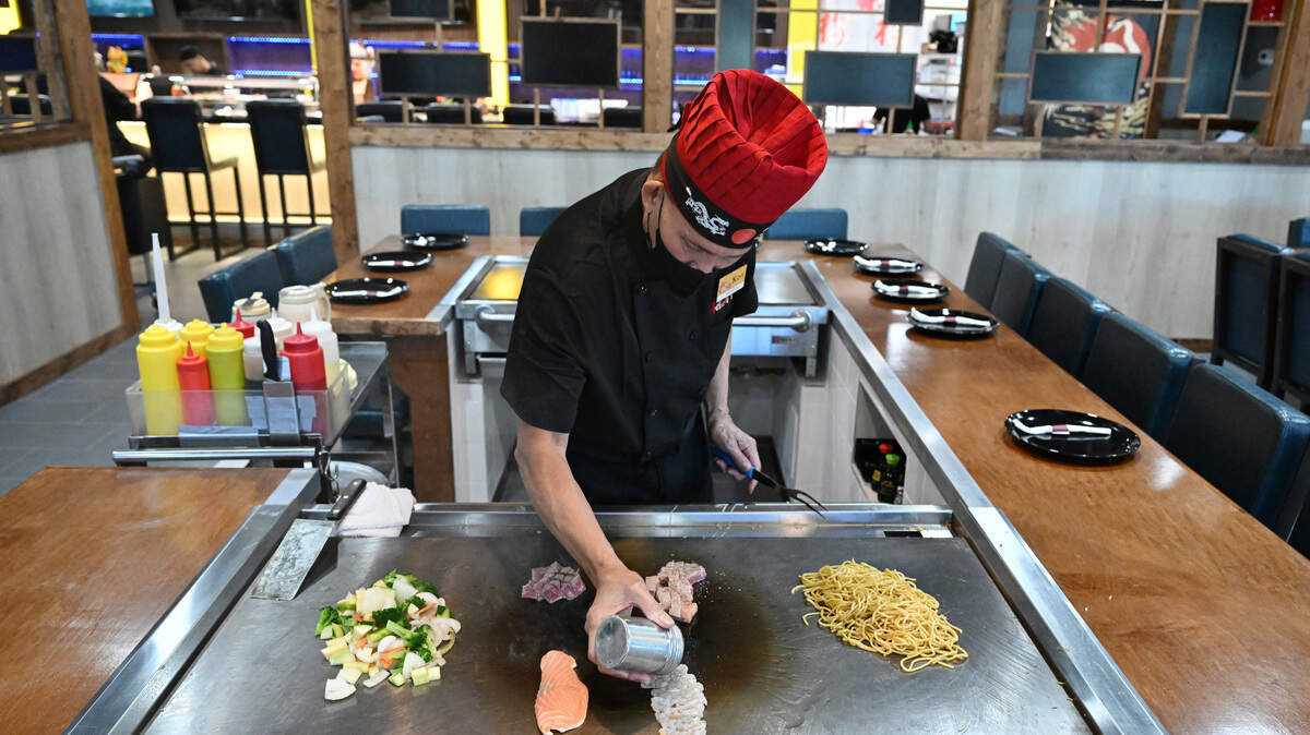Chef Roy “Toyota” Nooh seasons shrimp and other meats while cooking hibachi style at a teppanyaki table at the new Koji in Perry.