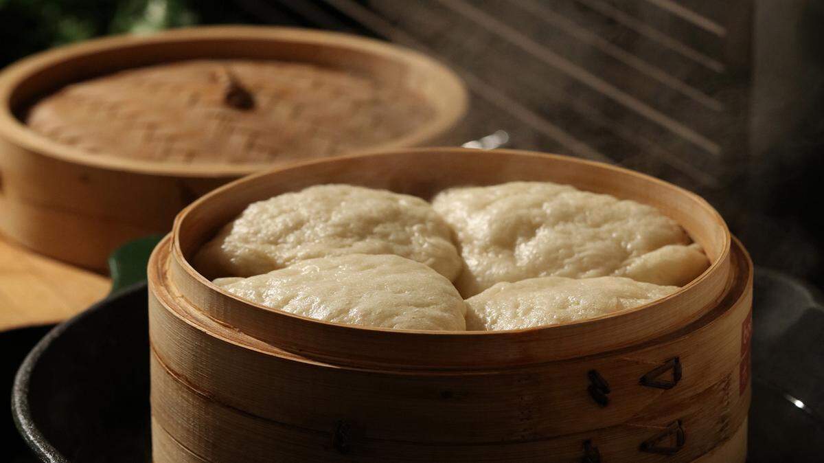 Homemade bao buns can be steamed in a traditional bamboo vessel, or in a more common metal steamer.