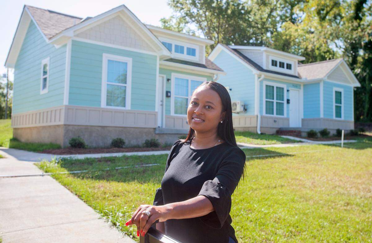 NyKhia Burke-Cummings, residential supervisor for River Edge Behavioral Health, stands out front of Maynard Village tiny home community in East Macon.