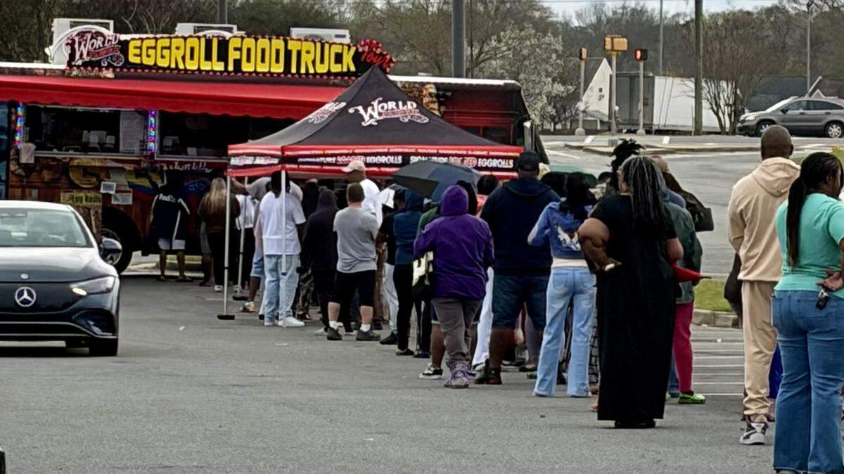 People line up at the World Famous Egg Roll Food Truck, known for its signature egg rolls like the Philly Cheesesteak and Mama’s Korean, at the parking lot of Lowe’s Home Improvement off Watson Boulevard at a previous stop on March 8, 2026.