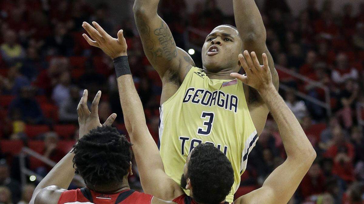 Georgia Tech's Marcus Georges-Hunt (3) shoots over North Carolina State's BeeJay Anya (21) and Caleb Martin during the second half of an NCAA college basketball game in Raleigh, N.C., Wednesday, Jan. 27, 2016. Georgia Tech won 90-83. (AP Photo/Gerry Broome)