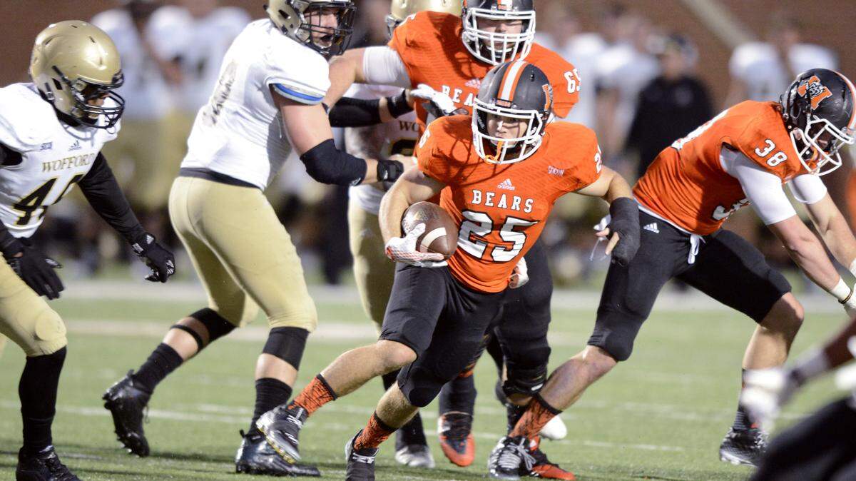Mercer running back Payton Usher (25) runs through a hole in the Wofford defense during their game Saturday night.