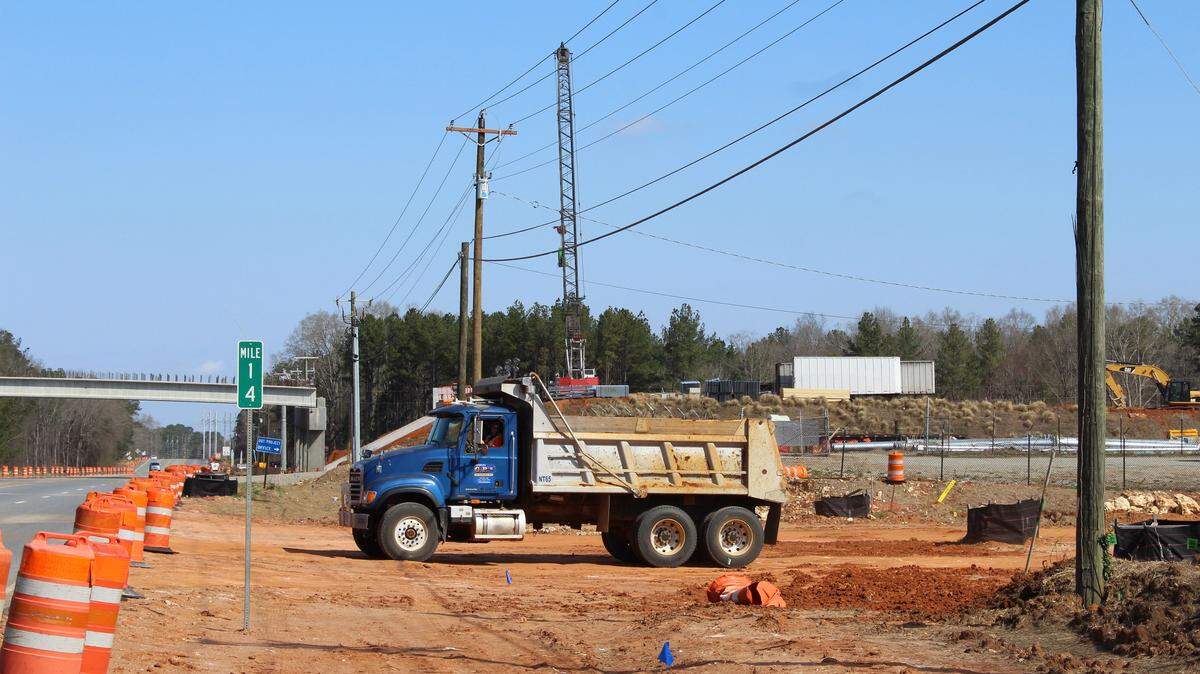 A dump truck Tuesday pulls out of the area on the southeast corner of the new section of Ga. 96 and Ga. 247 where a shopping center anchored by Publix is planned.