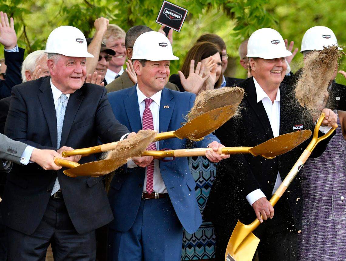 From left, University System of Georgia Chancellor Sonny Perdue, Gov. Brain Kemp and Jack Link’s founder Jack Link toss dirt Tuesday afternoon during a groundbreaking for a new Jack Link’s meat snacks facility in Perry.