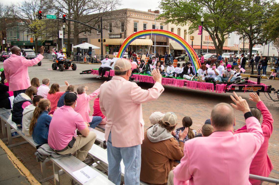 Cherry Blossom Festival dignitaries wave as a float rides down Cherry Street during the 39th Annual Cherry Blossom Parade Sunday.