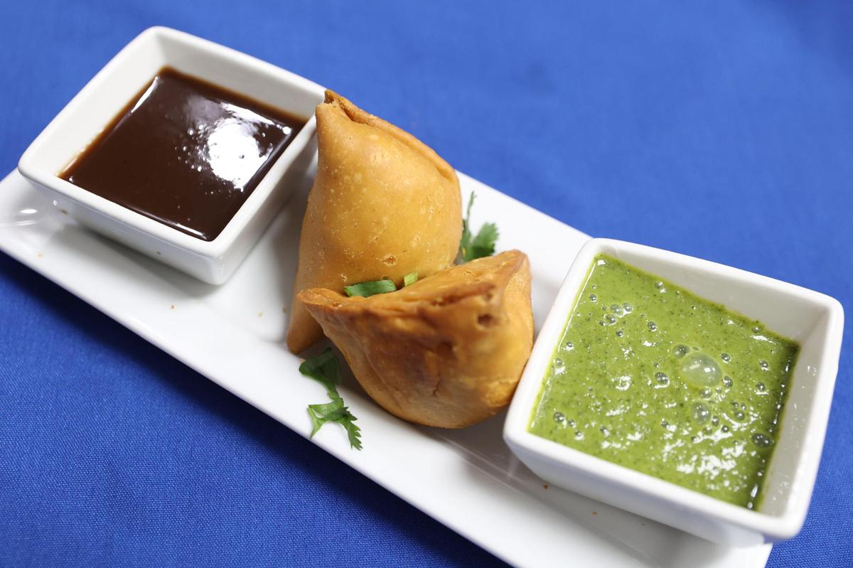 Samosas sit on a platter with tamarind (left) and mint chutney from Cook-in-Pot on Forsyth Street on Tuesday, Feb. 4, 2025, in downtown Macon, Georgia. The new restaurant offers a wide variety of authentic Indian, Mediterranean and Indo-Chinese dishes.