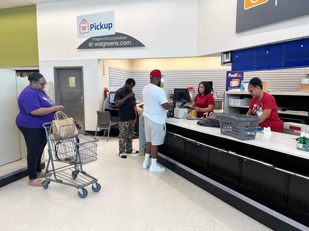 Sherrell Brown (left) waits in line to purchase makeup on Friday, May 16, 2025, before her neighborhood Walgreens at 4305 Mercer University Drive was expected to close a few days later. Bernadine Ortega (far right) was happy to be transferred to a new location.