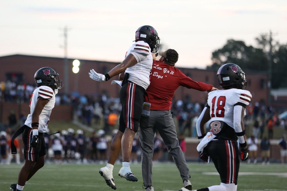 Warner Robins senior wide receiver Daymond Batts (0) celebrates with a Warner Robins coach after scoring the first touchdown of the football game between Warner Robins and Northside High Schools on Friday, Aug. 30, 2024, at McConnell Talbert Stadium in Warner Robins, Georgia. The Warner Robins High School football team defeated the Northside High School team 34-12.