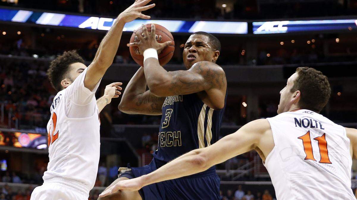 Georgia Tech guard Marcus Georges-Hunt (3) shoots between Virginia guard London Perrantes and forward Evan Nolte (11) during the first half of Thursday's ACC Tournament game.
