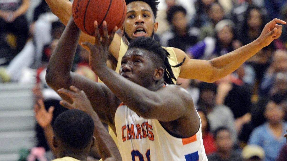 Central center Kentrevious Jones (00) puts a shot up after getting a rebound and is fouled by Westside's Steve Dophus (14) from behind.