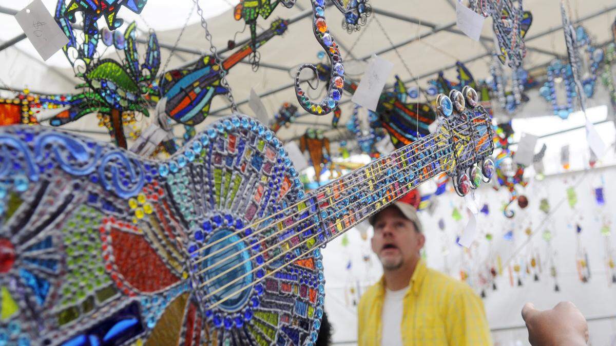 Visitors look at art glass at the 2011 Mulberry Street Arts and Crafts Festival in Macon.