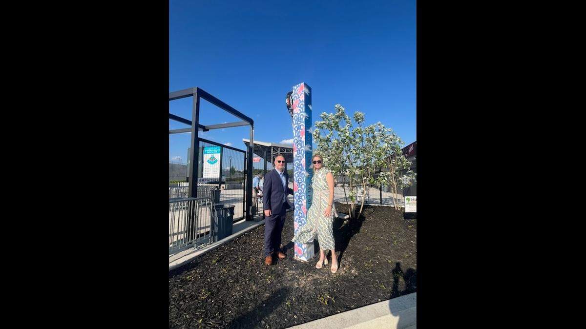 Mayor Lester Miller and Macon Rotary President Stephanie Folsom smile for a photo next to the newly dedicated Peace Pole at the Atrium Health Amphitheater on Monday.
