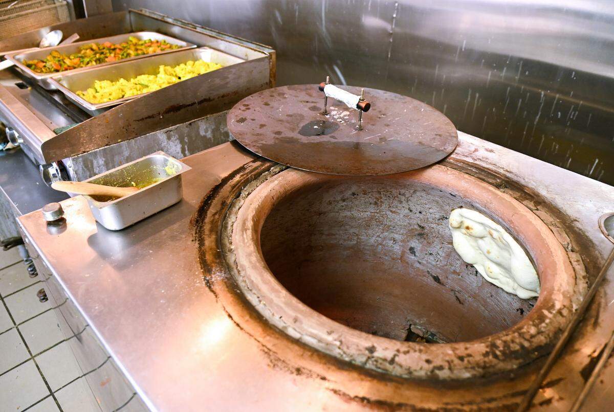 Naan, a type of flat bread popular in India, is baked in a tandoor oven at Bombay Curry in Macon.