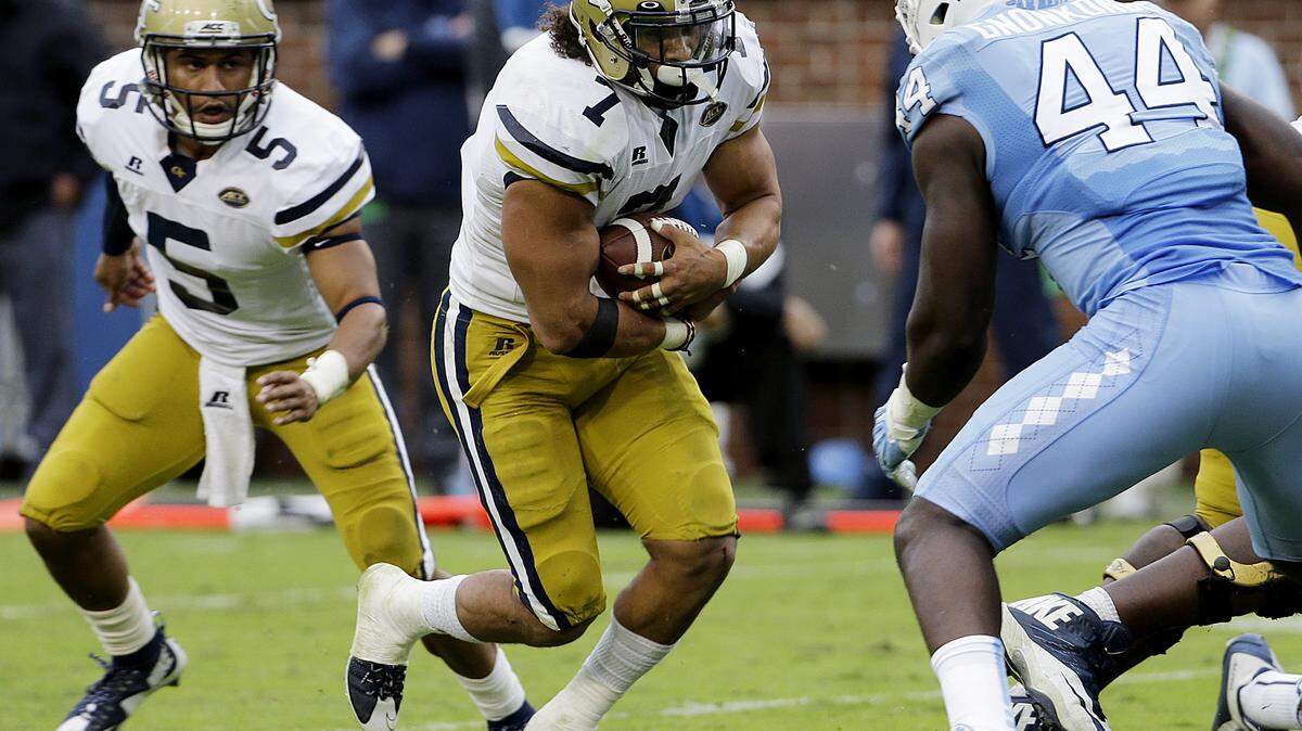Georgia Tech's Patrick Skov, center, runs the ball on a handoff from quarterback Justin Thomas, left, as North Carolina's Junior Gnonkonde, right, defends in the third quarter of an NCAA college football game Saturday, Oct. 3, 2015, in Atlanta. North Carolina won 38-31. (AP Photo/David Goldman)