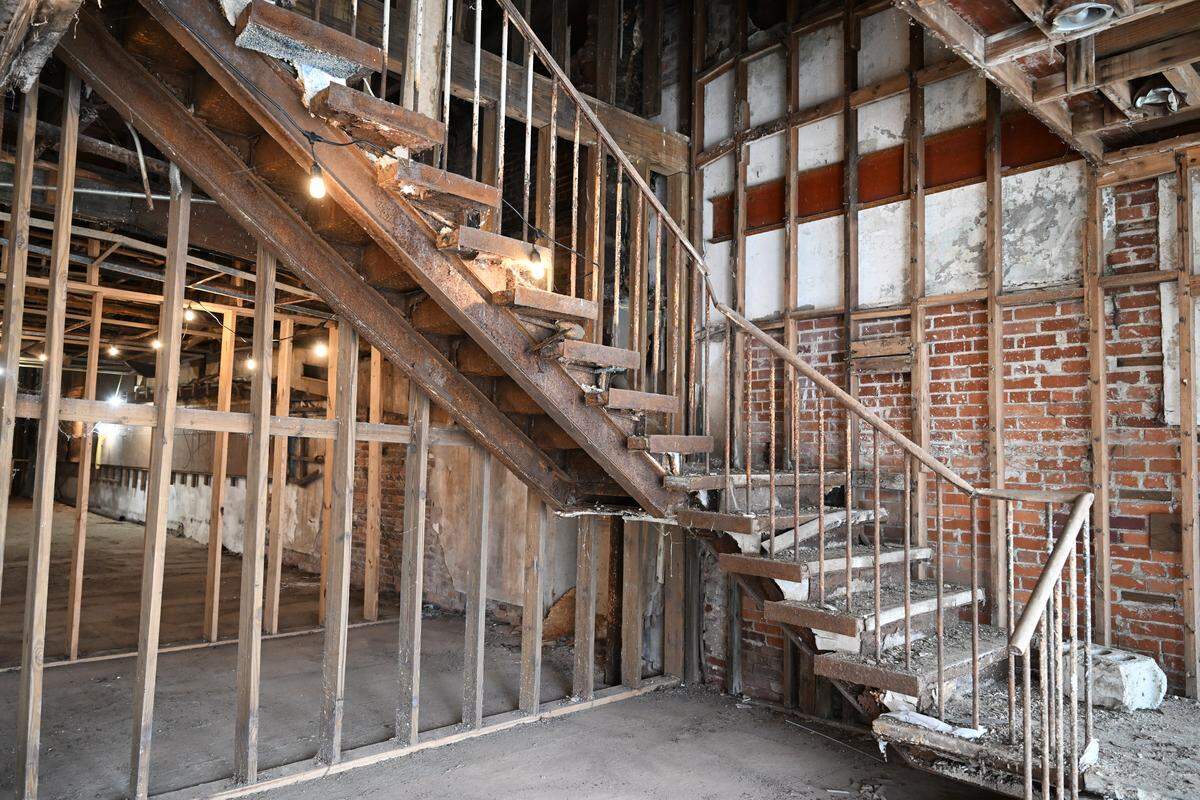 Cobwebs and dust hang off the front stairs inside of the Bibb Theatre on Thursday, Feb. 5, 2026, in Macon, Georgia. The front area will become a glass recording studio for The Creek 100.9 FM in the building renovations. 