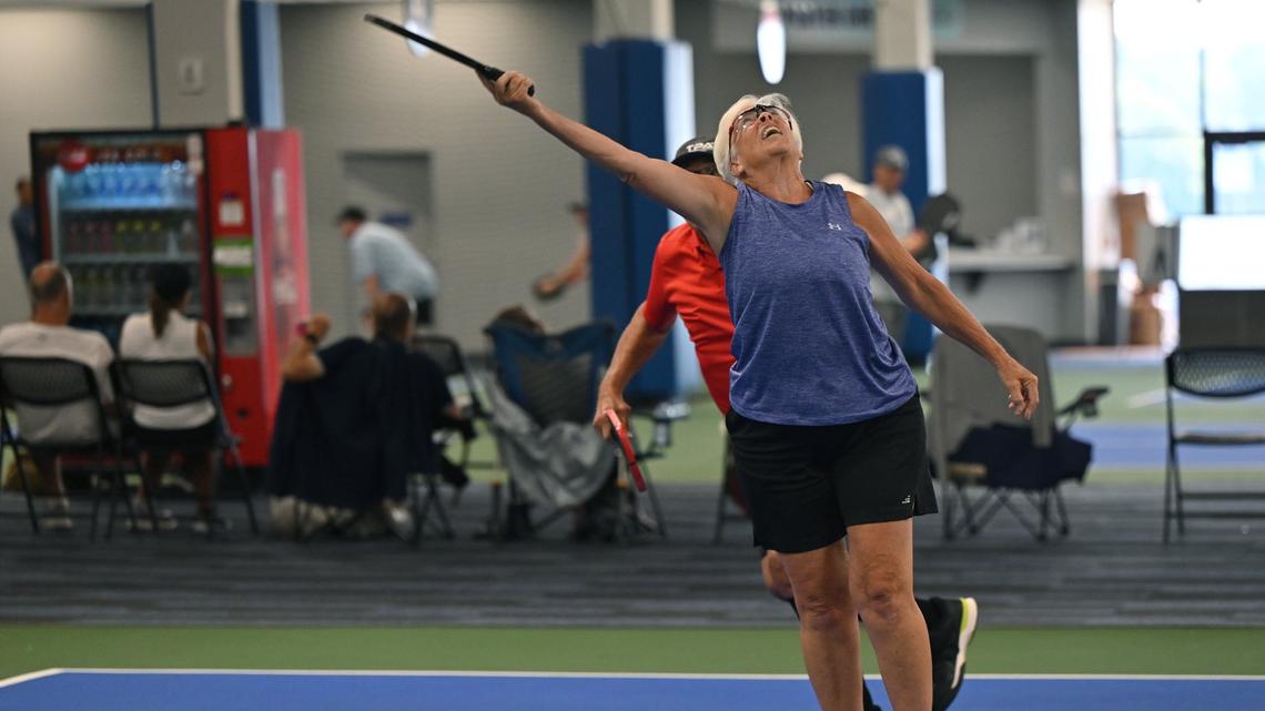 Betsey Lieberman, 72, from Tallahassee, Florida, reaches for the ball during a mixed doubles match on the second day of the United States Senior Pickleball Indoor National Championships on Saturday, July 13, 2024, at Rhythm and Rally Sports & Events in Macon, Georgia. United States Senior Pickleball hosted its inaugural indoor national championships this year, spanning three days and bringing hundreds of seniors to compete in Macon from across the country.