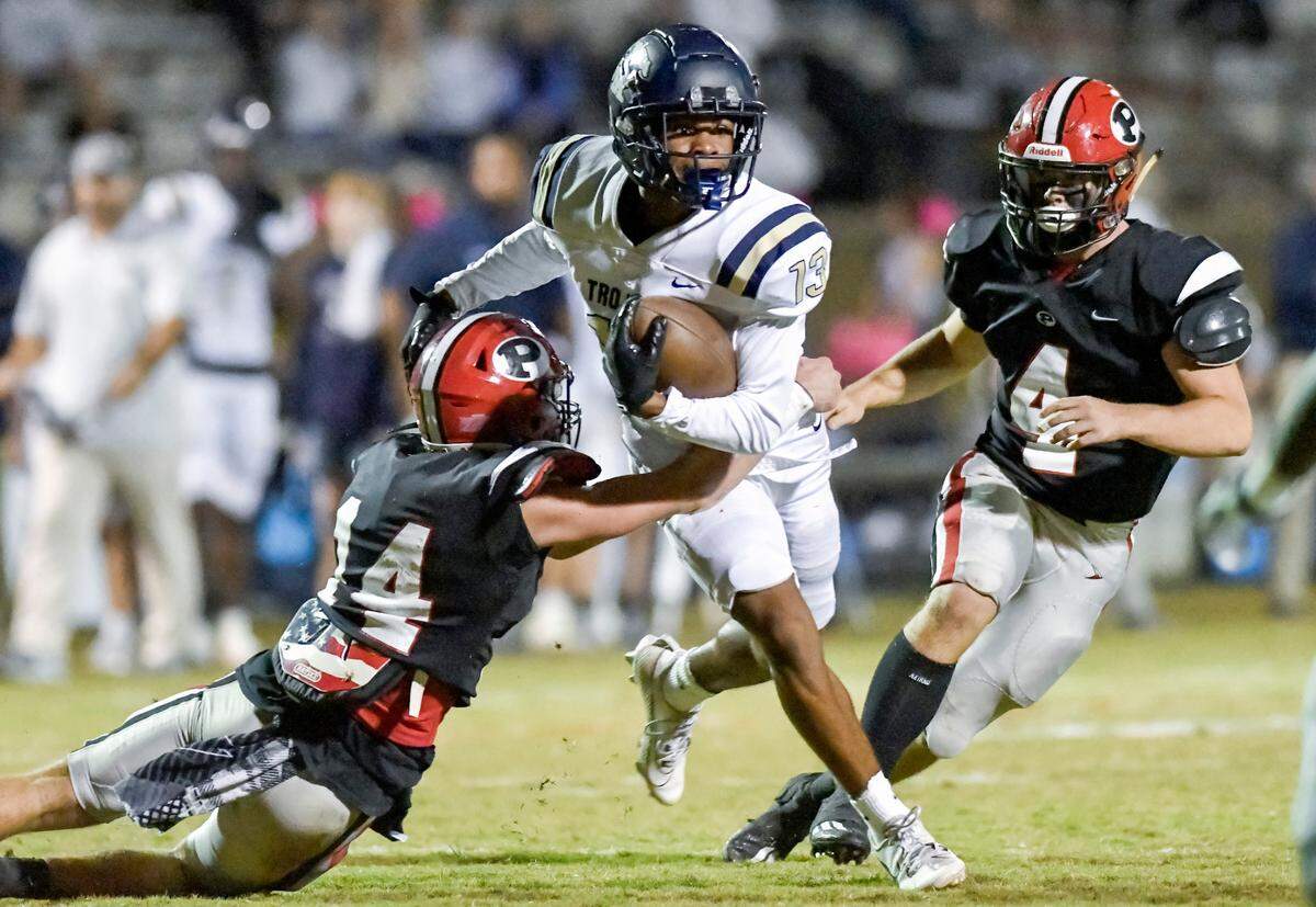 John Milledge receiver Jalen Butts (13) breaks a tackle during the Trojans win over FPD Friday night.