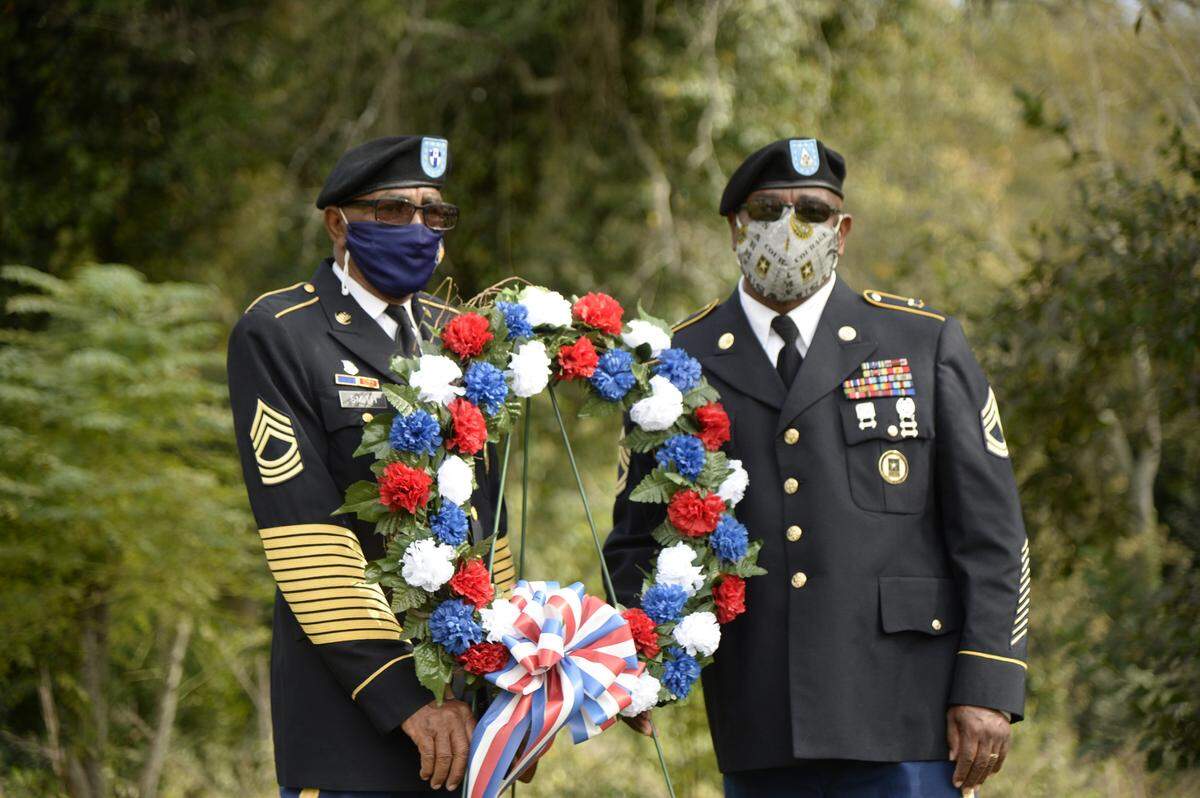 Members of Charlie Company 148th Brigade place a ceremonial wreath on a grave at a Veterans Day ceremony at Linwood Cemetery in Macon Thursday morning. The event was hosted by the Macon Cemetery Preservation Corporation.