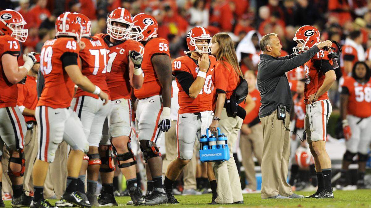 While the rest of the offense huddled to plan a field goal in the final seconds against Missouri, Georgia head coach Mark Richt meets with his place-kicker, Marshall Morgan, right, in the Bulldogs' victory.