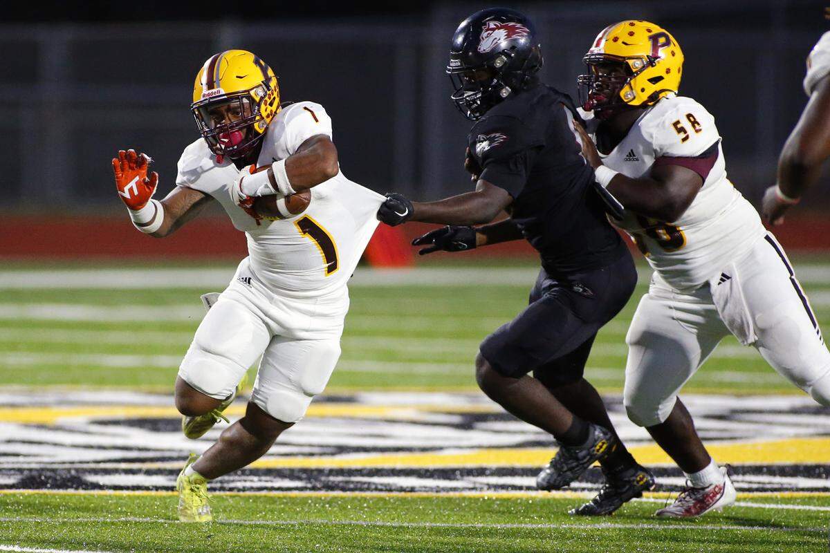 Perry’s #1 Ahmad Gordon (1) can not shake a tackle from Howard’s Khalid Miller (8) duirng their game Friday night.