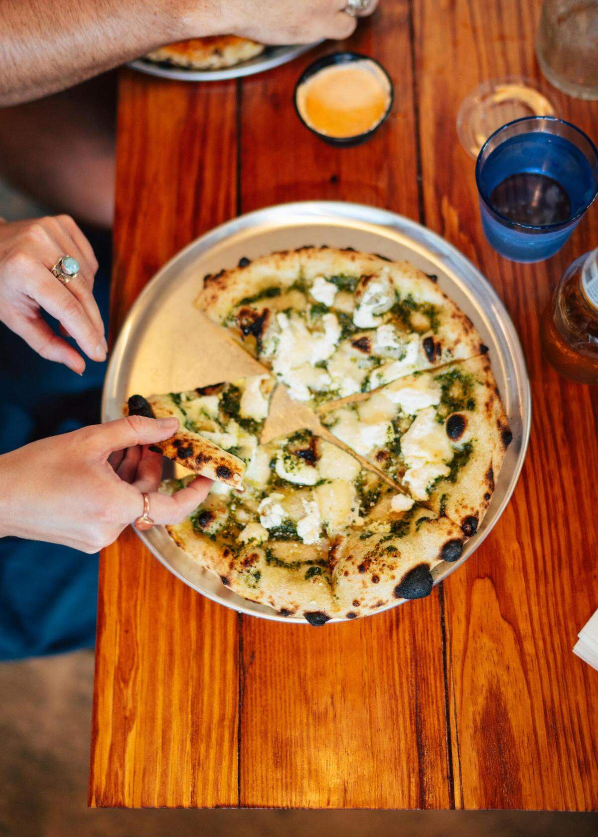 A pesto pizza with olive oil, goat cheese, garlic capers and lemon-tossed arugula at Ghost Runner Pizza in historic downtown Perry.